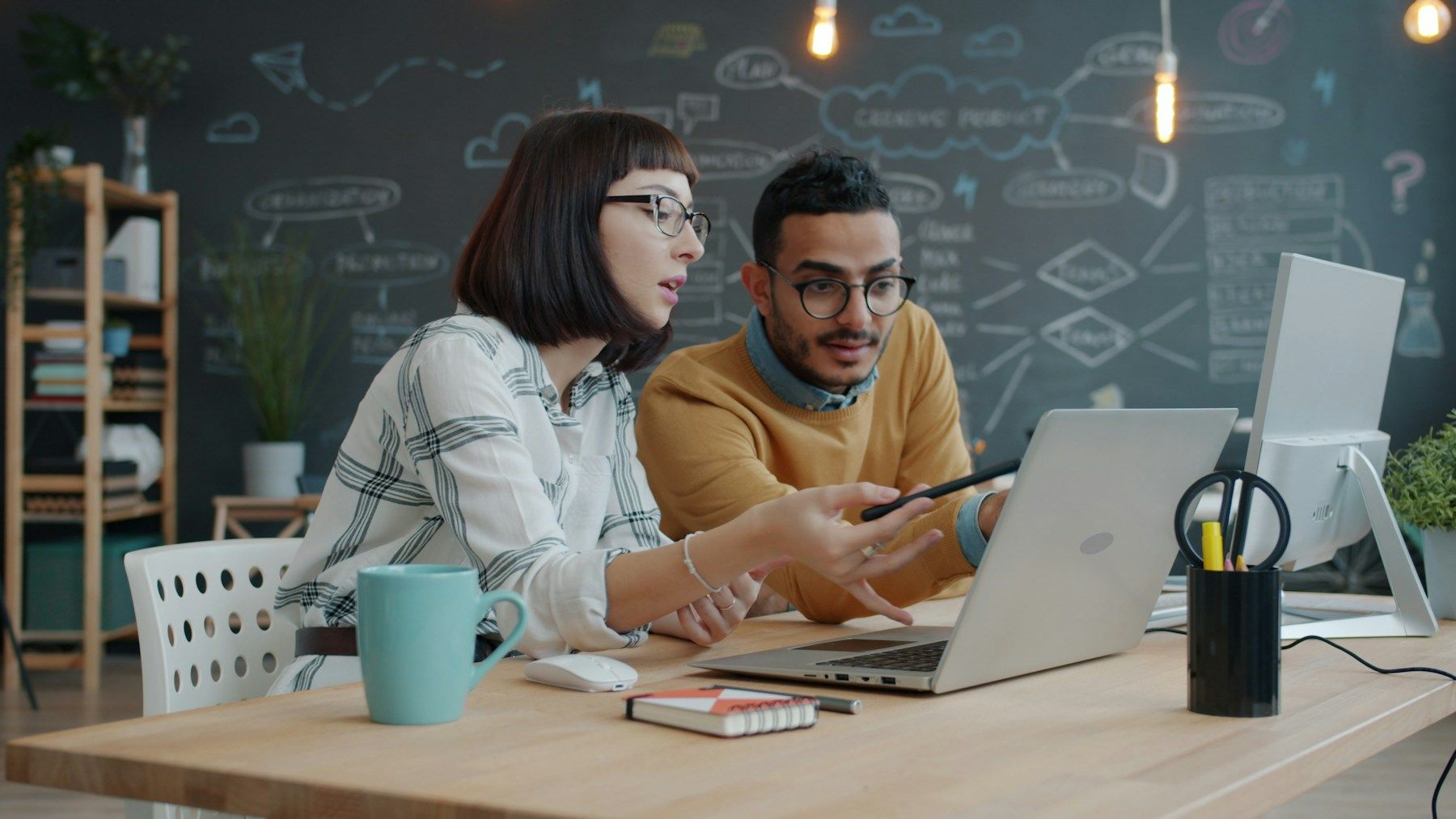Two colleagues reviewing an automated workflow together
